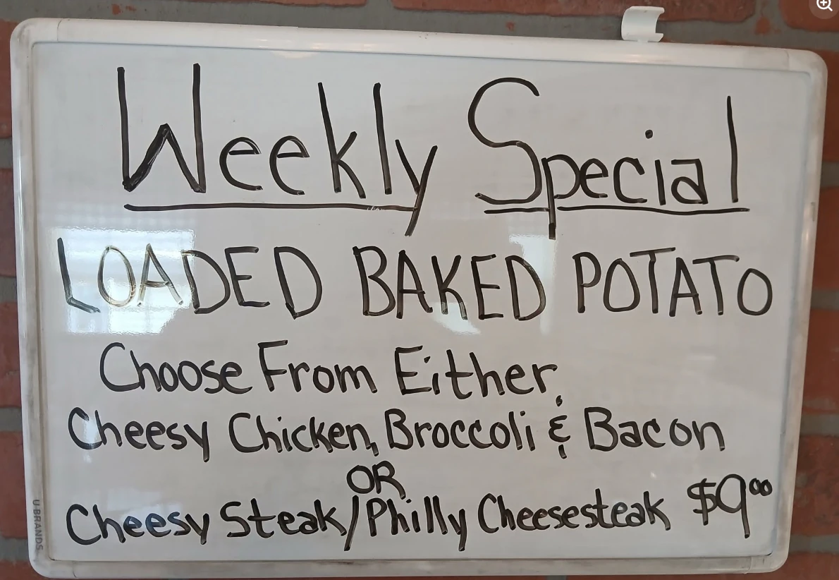 Amazing Grace weekly special board featuring a loaded baked potato